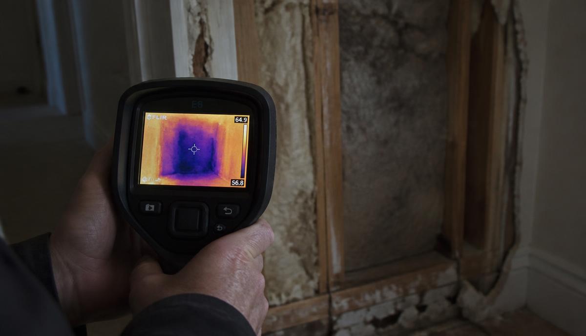 Thermal camera revealing hidden moisture inside a wall